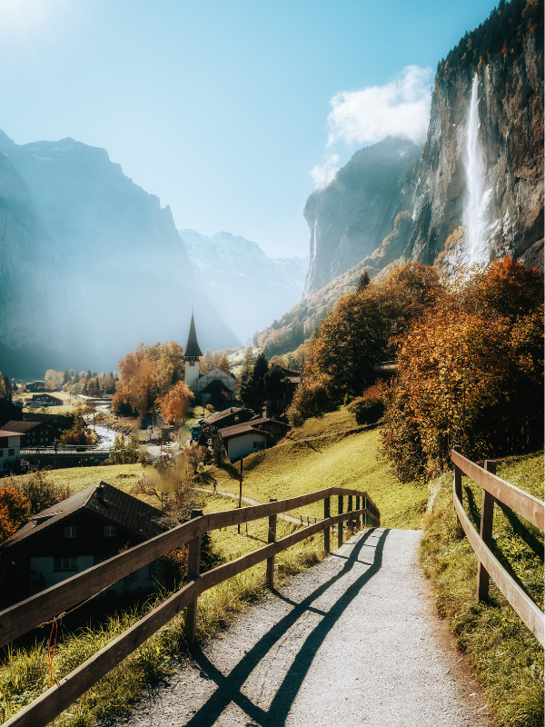 Dolina Lauterbrunnen w Szwajcarii z malowniczym wodospadem, górską ścieżką i alpejską wioską w jesiennej scenerii