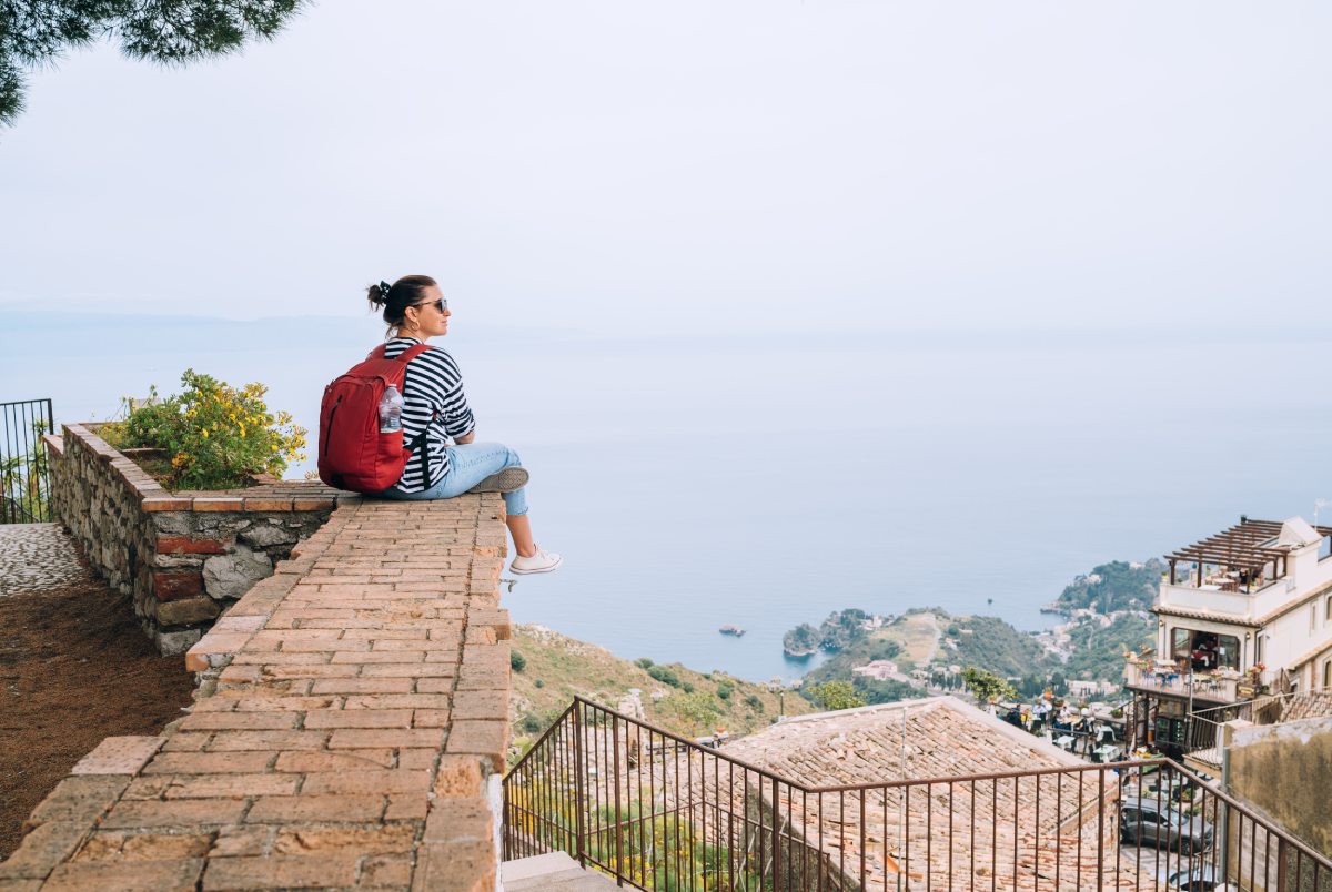 Woman sitting on a wall in Sicily © iStock