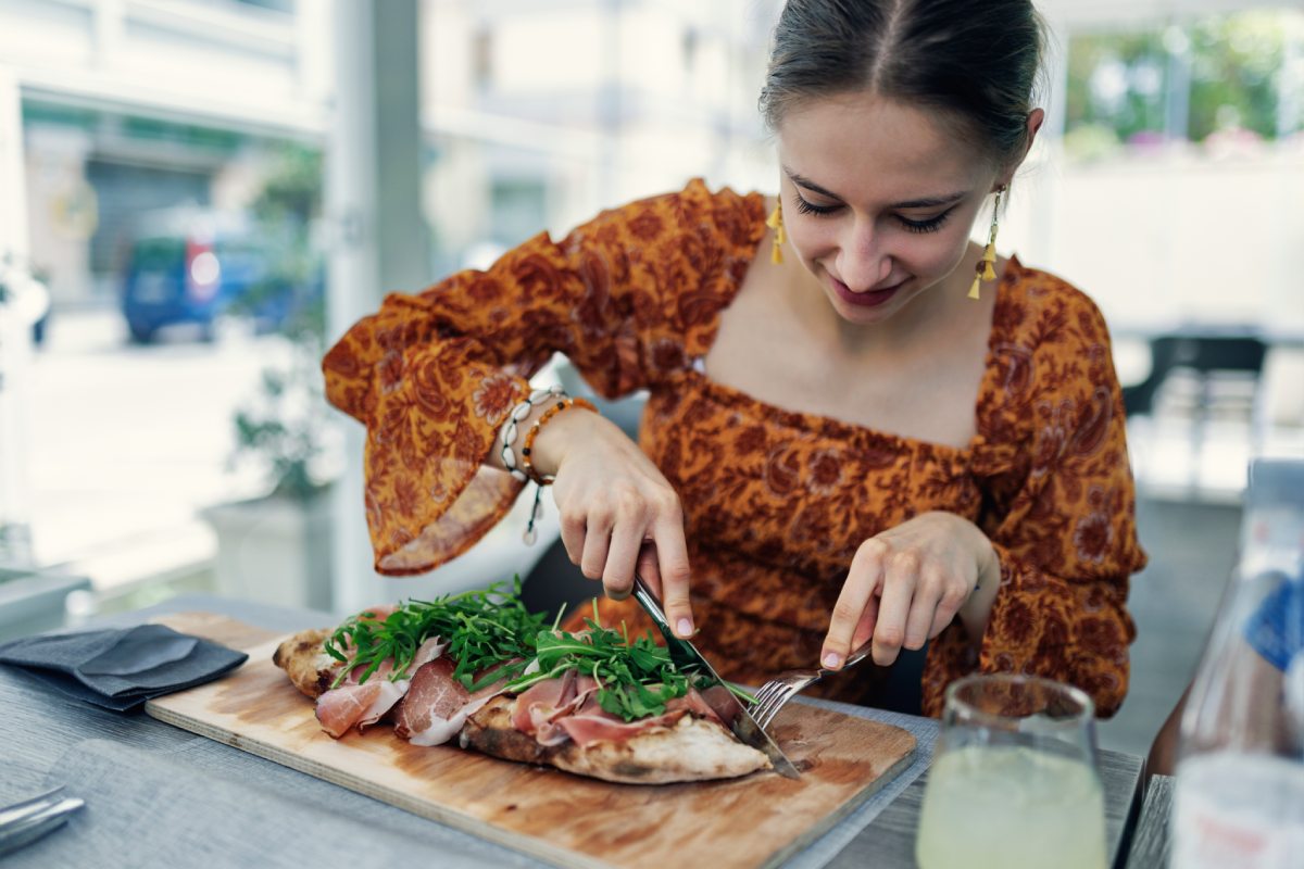 Woman eating pizza in a Sicilian restaurant © iStock