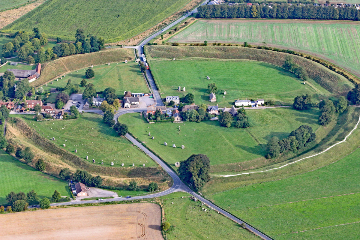 Zdjęcie lotnicze przedstawiające neolityczny kamienny krąg w Avebury w Wielkiej Brytanii, widoczne są pola, drogi i zabudowania znajdujące się w obrębie tego starożytnego zabytku.