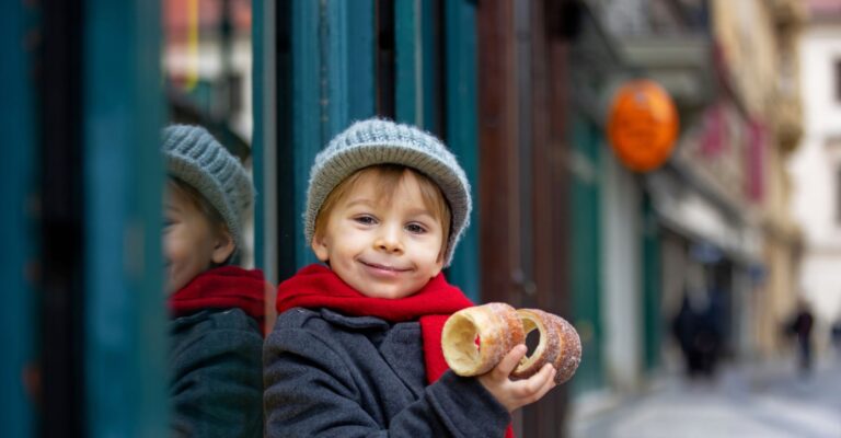 Dziecko w centrum Pragi, jedzące tradycyjny czeski deser © Shutterstock