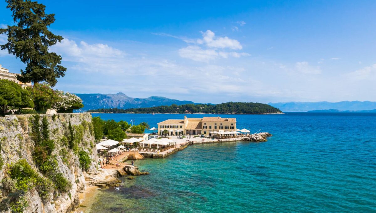 Faliraki na Korfu z łaźniami publicznymi i plażą z wysepką Vido w tle na wyspie Korfu, Grecja © Shutterstock