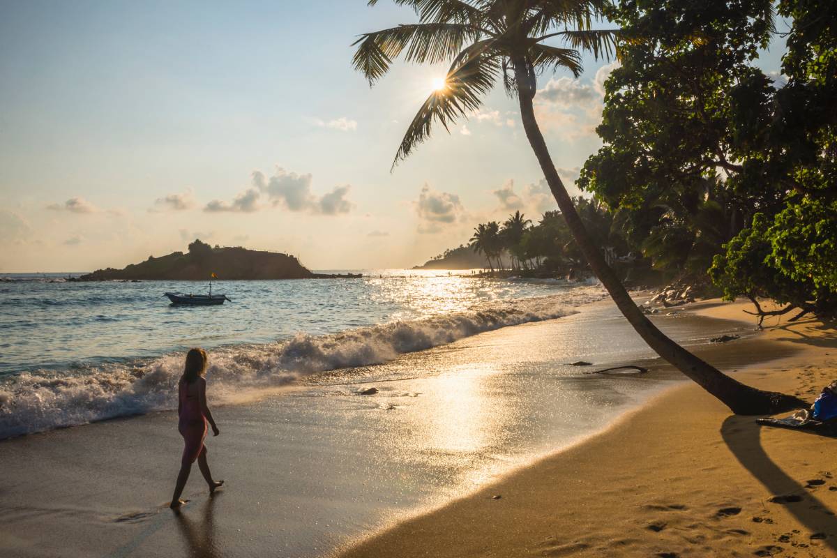 Kobieta spacerująca po plaży Mirissa o zachodzie słońca, Sri Lanka © Shutterstock