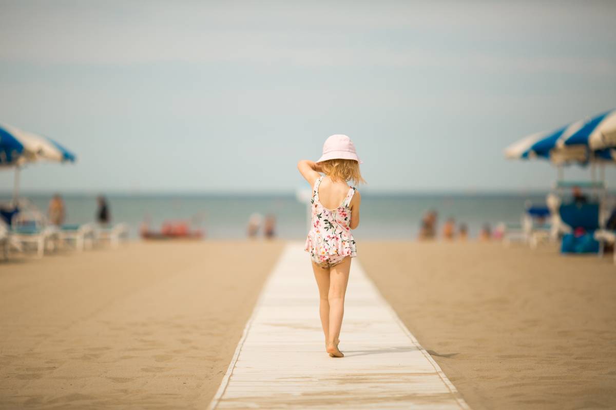 Mała dziewczynka spaceruje po plaży w Viareggio, Włochy © Shutterstock
