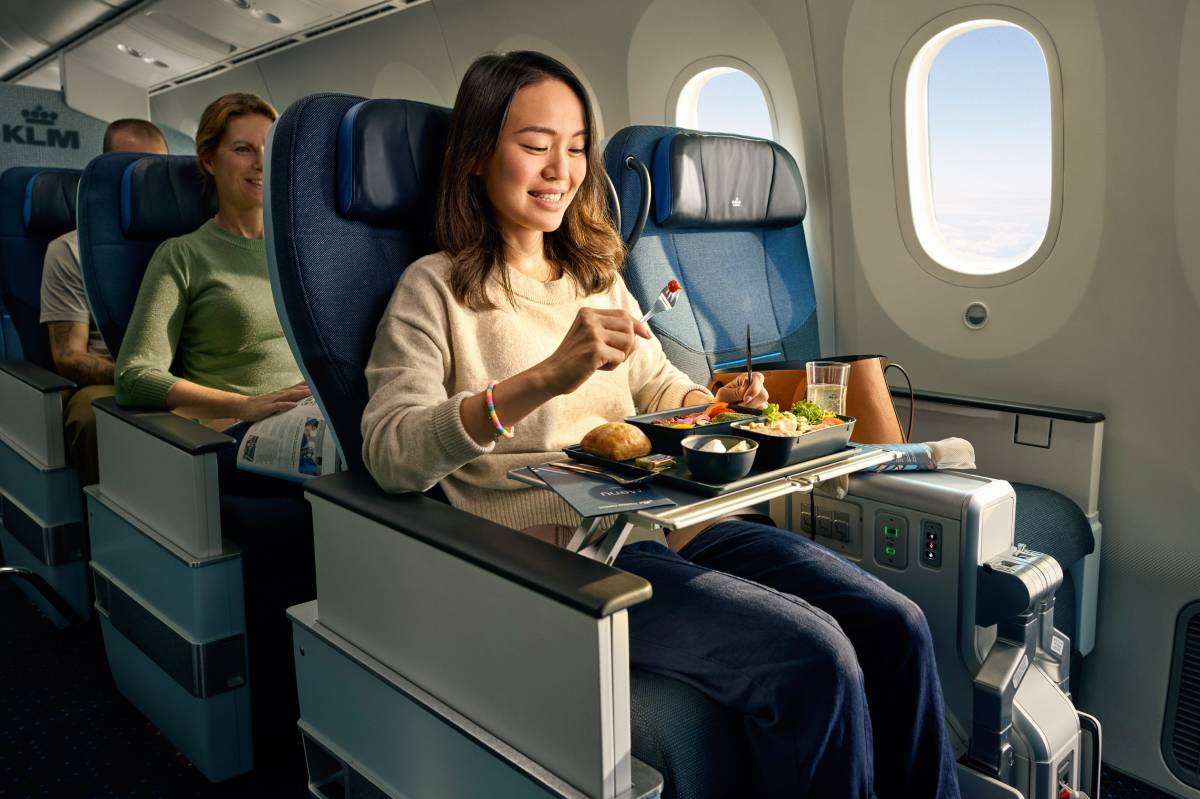 Komfortowa podróż w klasie Premium Comfort linii KLM – pasażerka cieszy się wysokiej jakości posiłkiem na pokładzie nowoczesnego samolotu. Więcej miejsca, wygodne fotele i ekskluzywne usługi sprawiają, że podróż staje się przyjemniejsza. Odkryj różnice między taryfami KLM i wybierz najlepszą opcję dla siebie