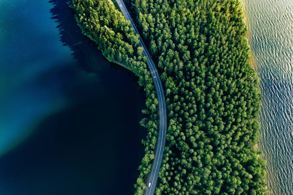Widok z lotu ptaka na drogę pośród zielonych lasów i błękitnych jezior w letniej Finlandii © Shutterstock
