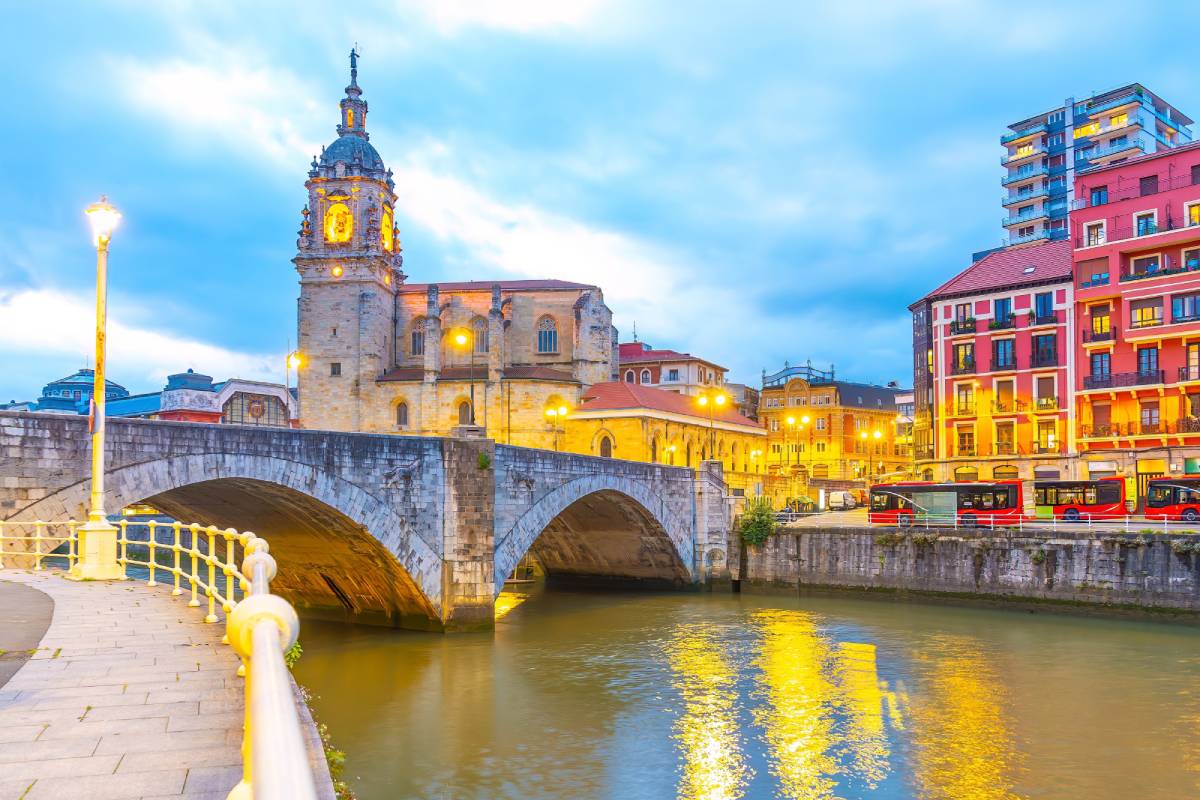 Zabytkowe kamienne łuki mostu San Anton i kościoła San Anton odbijają się w rzece Nervion, Bilbao, Hiszpania © Shutterstock