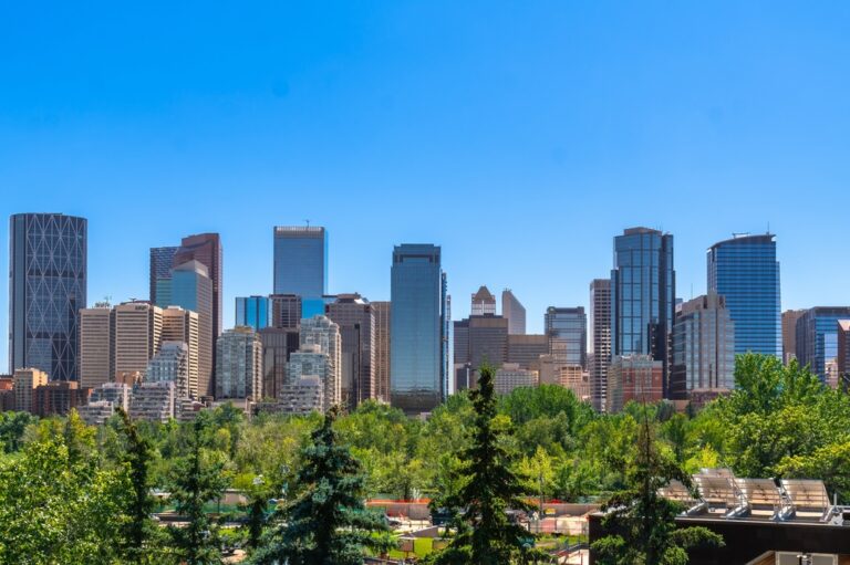 Panorama Calgary w Kanadzie – nowoczesne wieżowce centrum miasta otoczone zielenią drzew w słoneczny dzień