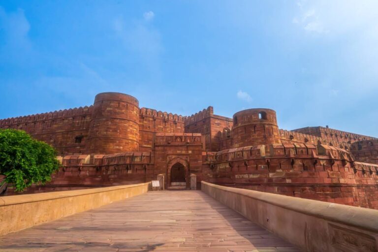Główne wejście do Czerwonego Fortu w Agrze w Indiach, z masywnymi czerwonymi murami z piaskowca, pod błękitnym niebem