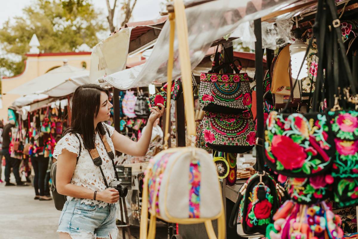 podróżnik dziewczyna kupuje pamiątki w tradycyjnym meksykańskim rynku na ulicach Meksyku, Hiszpanie turystów stojących na zewnątrz © Shutterstock