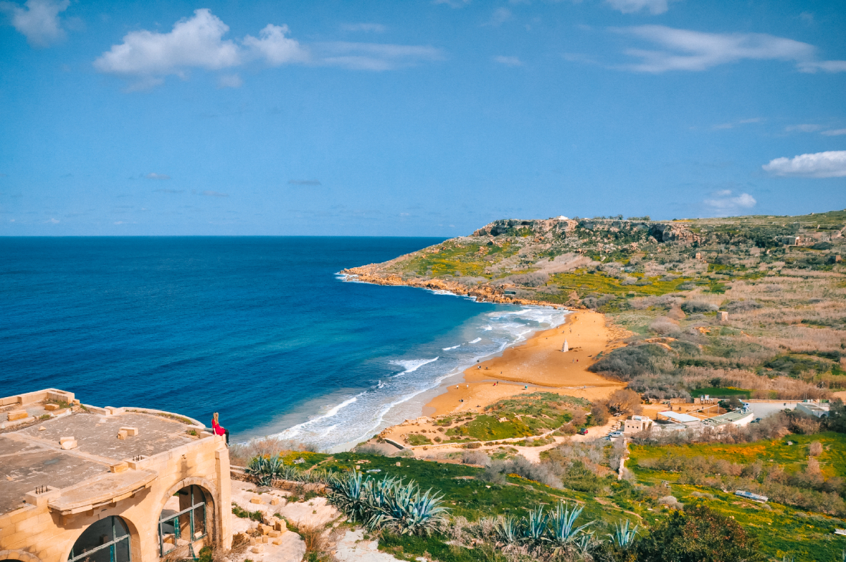 Panorama Ramla Bay na wyspie Gozo, Malta – szeroka piaszczysta plaża otoczona wzgórzami i Morzem Śródziemnym.