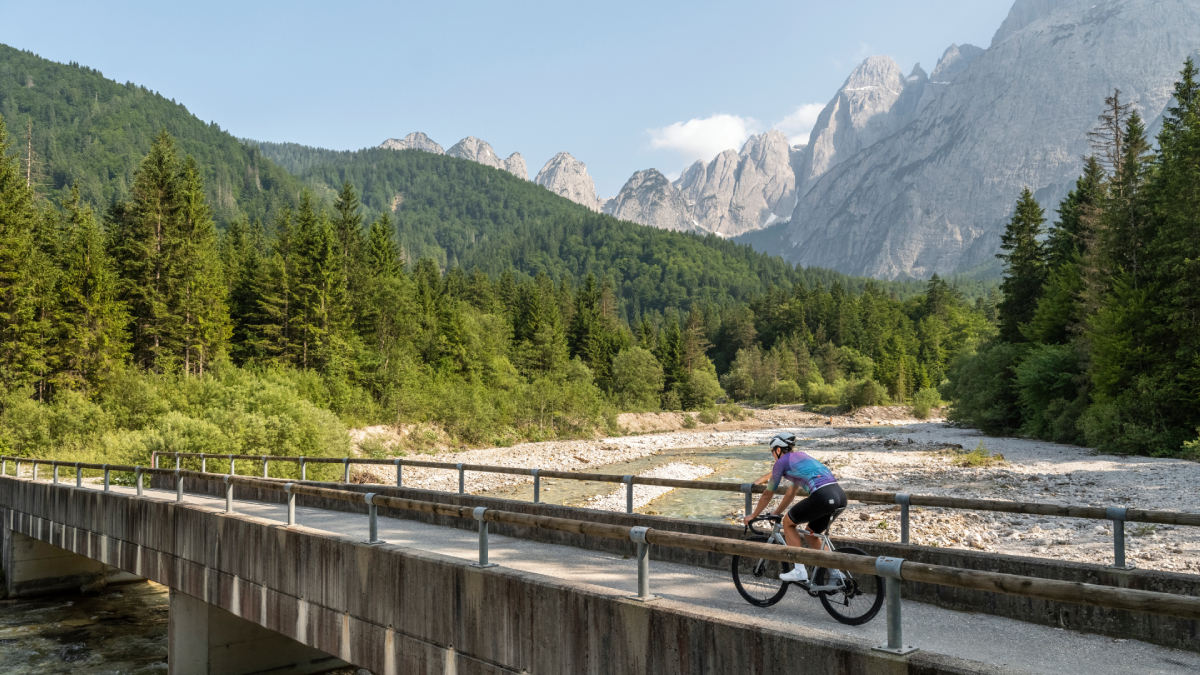 Rowerzysta na moście w Alpach Julijskich, Friuli-Wenecja Julijska – malownicza trasa rowerowa wśród gór i lasów.