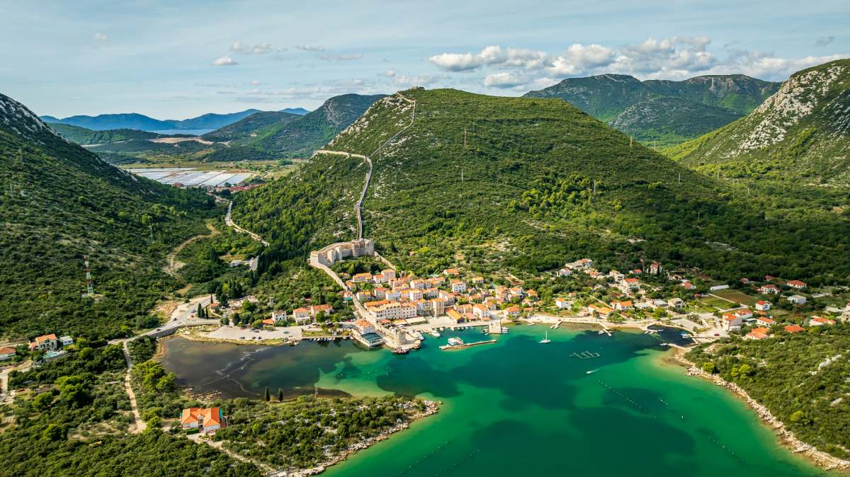 Panoramiczny widok na Ston w Chorwacji z monumentalnymi murami obronnymi i turkusową wodą Adriatyku, popularne miejsce w Dalmacji.