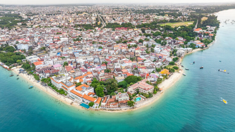 Panoramiczne ujęcie Stone Town na Zanzibarze, widziane z lotu ptaka, otoczone turkusowymi wodami Oceanu Indyjskiego.