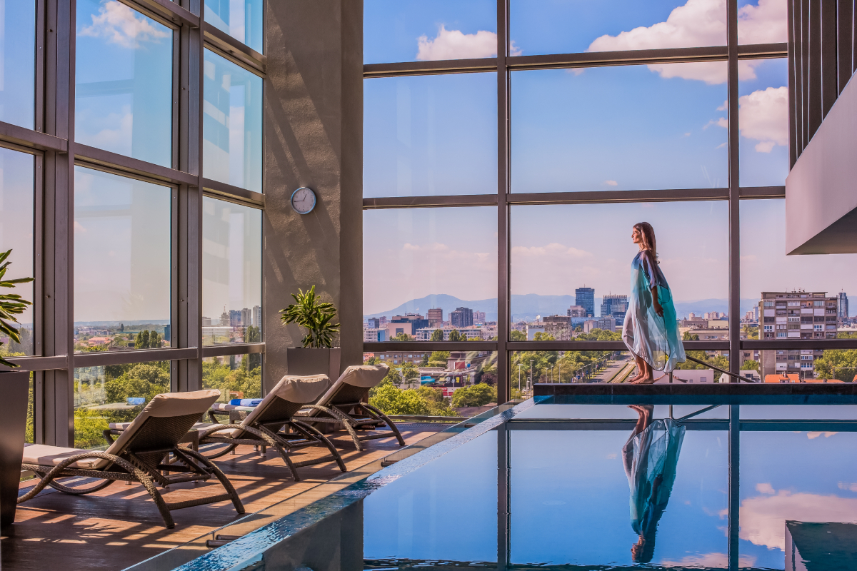 Nowoczesny basen w hotelu w Zagrzebiu z panoramicznym widokiem na miasto i góry w tle, idealne miejsce na relaks w stolicy Chorwacji.